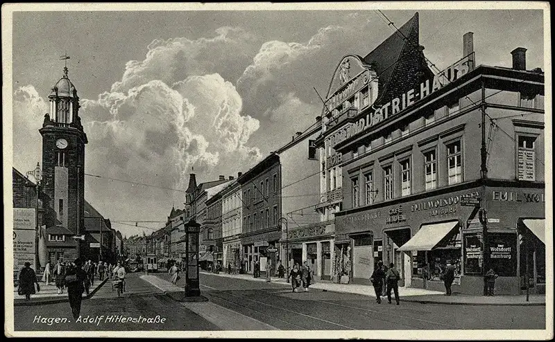 Altes Foto der Stadt Hagen 1938, Blick über den heutigen Berliner Platz auf den Bahnhof. In der unteren linken Ecke steht: Hagen. Adolf Hitlerstraße. Dramatisch retuschierter Wolkenhimmel.